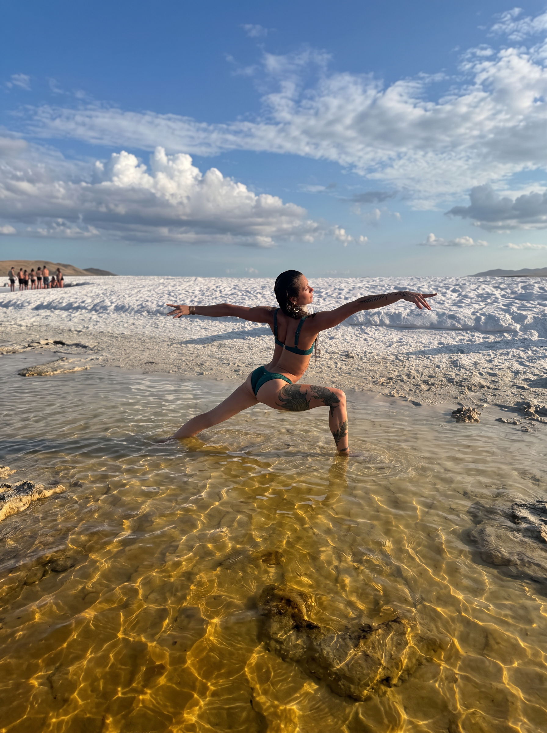 Kera Lynn practicing warrior pose in golden ocean water